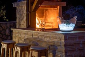 a stone bar with stools and a fireplace at Luxury Villa Allen with Pool in Klimno +45 photos
