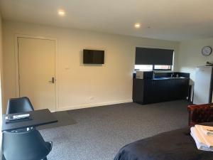 a room with a bed and a desk and a television at Queens Arms Hotel in Longford