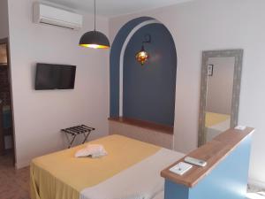 a room with a bed and a mirror and a tv at Pension Arena Alicante in Alicante