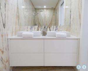 a white bathroom with two sinks and a mirror at RS Porto Campanha in Porto