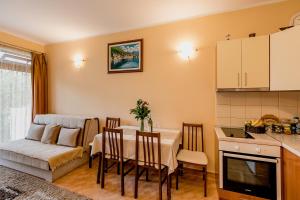 卡門納里的住宿－古德耶公寓酒店，厨房以及带桌子和沙发的用餐室。