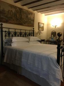 - une chambre avec un grand lit et des draps blancs dans l'établissement Casa San Roque, à Chinchón
