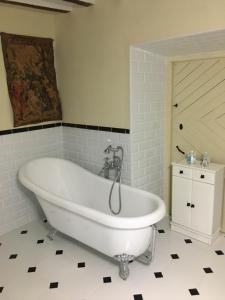 a white bath tub in a bathroom with a tile floor at Casa San Roque in Chinchón