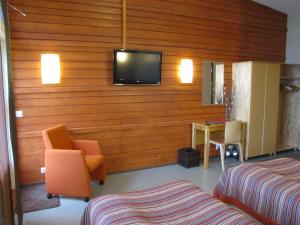 a hotel room with a tv on a wooden wall at Jokiniemen Matkailu in Alapitkä