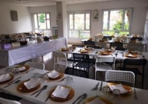 a dining room with tables and chairs with plates and napkins at Llanes International Hostel in poo de Llanes +33 photos