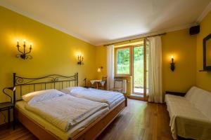 a yellow bedroom with a bed and a window at Bühnenwirtshaus Juster in Gutenbrunn