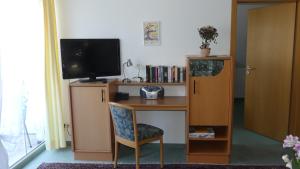 a desk with a television and a desk with a chair at Ferienwohnung Mittl in Bad Wörishofen