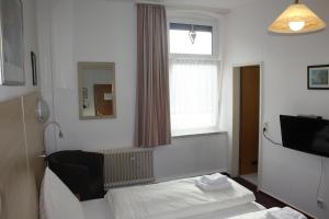 a hotel room with a bed and a window at Hotel Am Kamin in Duisburg