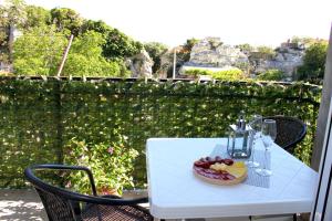 a white table with a bowl of fruit and wine glasses at Apartments Nature in Omiš