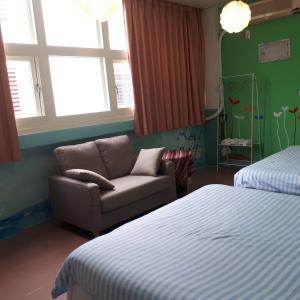 a bedroom with a couch and a bed and windows at Taroko Susi Space in Xincheng