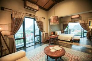 a hotel room with a bed and a balcony at Le Clos Du Fil in Ninh Binh