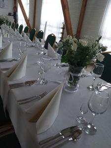 a table with white napkins and a vase of flowers at Grochowiak in Grochów