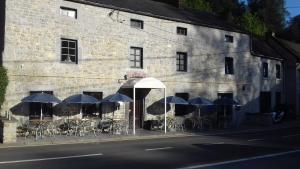 een groep tafels met parasols voor een gebouw bij studio cosy in Gesves