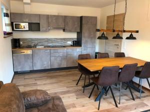 uma cozinha e sala de jantar com uma mesa de madeira e cadeiras em Haus Marjanne em Niederau