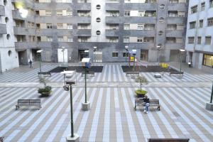 una persona sentada en un banco en un edificio en Hotel Alda Estación Oviedo, en Oviedo