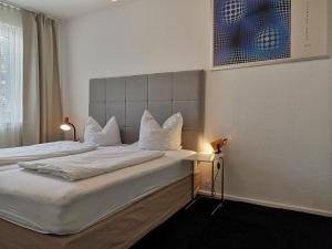 1 Schlafzimmer mit 2 Betten mit weißer Bettwäsche und Kissen in der Unterkunft M M Central Vintage Family, Handwerker und Monteure Apartments in Berlin