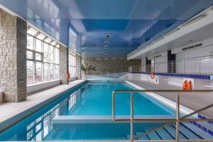 a large swimming pool with blue water in a building at Rysy in Bukowina Tatrzańska