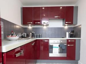 a kitchen with red cabinets and a red oven at Valdeni Apartments in Leeds