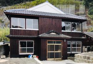 una casa de madera con muchas ventanas en 屋久杉楼 七福 en Yakushima