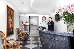 a woman standing at a bar in a room at Hotel Casa Mahanaim Colferias, Bogotá in Bogotá