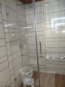 ein Badezimmer mit einer Glasdusche mit einer Glastür in der Unterkunft Hotel Jyoti in Forbesganj