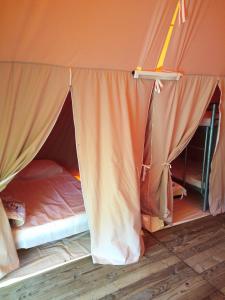 a bed in a tent in a room at Camping de Marcilly sur Vienne in Marcilly-sur-Vienne
