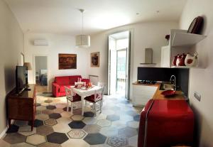 a kitchen and living room with a red couch and a table at Casa Tilde Bacoli in Bacoli