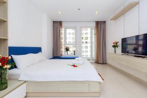 1 dormitorio con 1 cama grande y TV en Sky homes Block A, en Ho Chi Minh