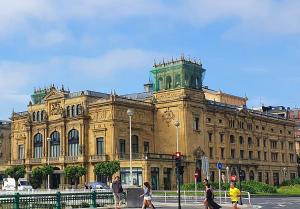 um grande edifício com uma torre de relógio em cima em Pensión Nuevas Artes em San Sebastián