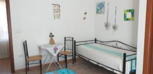 a bedroom with a bed and a table and a chair at Bed and Breakfast Le petunie in Bari Sardo