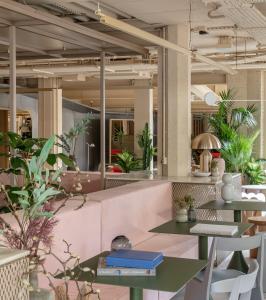 un restaurante con mesas, sillas y plantas en Locke at Broken Wharf, en Londres