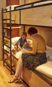 a woman and a child sitting on a bunk bed at City Center Lodge Utrecht in Utrecht