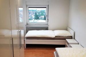 Habitación pequeña con cama y ventana en Stadtwohnung in Eppelheim bei Heidelberg en Eppelheim