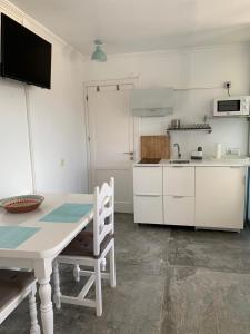 a white kitchen with a table and a table and chairs at Estudio Naos in Arrecife