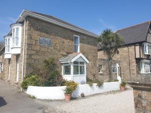 a brick building with a palm tree in front of it at Bay Lodge in Penzance