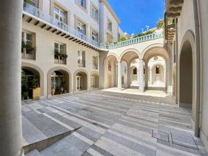 an empty courtyard of a building with arches at One in Palermo