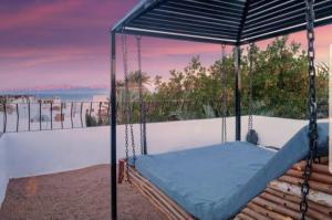 uma cama de baloiço numa varanda com vista para o oceano em Villa Can Kiko em Dahab
