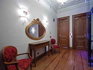 イスタンブールにあるセリーヌ ホテル オットマン マンションの鏡、デスク、椅子が備わる客室です。