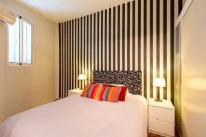 ein Schlafzimmer mit einem großen weißen Bett mit zwei Lampen in der Unterkunft Plaza Nueva Terraza in Sevilla