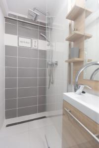 uma casa de banho com um chuveiro e um lavatório. em Silver House vendégház em Orosháza