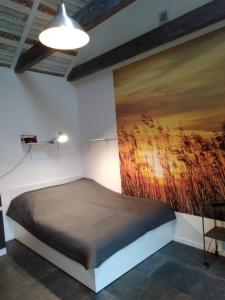 Ce lit se trouve dans un dortoir orné d'une peinture murale. dans l'établissement Domek nad Jeziorem, à Zyndaki