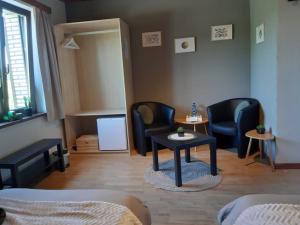 una habitación con 2 sillas y una mesa en una habitación en B&B Circuitez-vous, en Stavelot