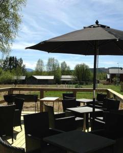 a patio with tables and chairs and an umbrella at Sonfjällsgårdens Wärdshus & Hotell in Hede