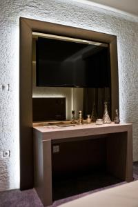 a bathroom with a sink and a large mirror at Mirage Hotel Sárvár in Sárvár