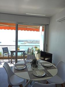 einen Esstisch und Stühle mit Blick auf einen Balkon in der Unterkunft APPARTEMENT TERRASSE VUE MER Sea view terrace apartment "Etoile de Mer" in Menton