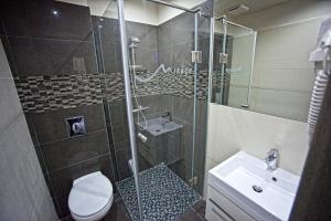 a bathroom with a shower and a toilet and a sink at Mirage Hotel Sárvár in Sárvár