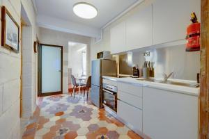 バレッタにあるCentral and Cosy 2BR Apartment in Vallettaの白いキャビネットとテーブル付きのキッチン