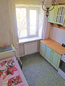 une petite cuisine avec une table et une fenêtre dans l'établissement Однокомнатная квартира на улице Попудренко, à Kiev