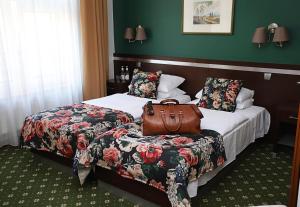 une chambre d'hôtel avec deux lits et un sac sur un siège dans l'établissement Hotel i Restauracja "Pod Orłem", à Kartuzy