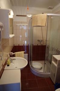 a bathroom with a sink and a shower at Atlas Apartman in Bük